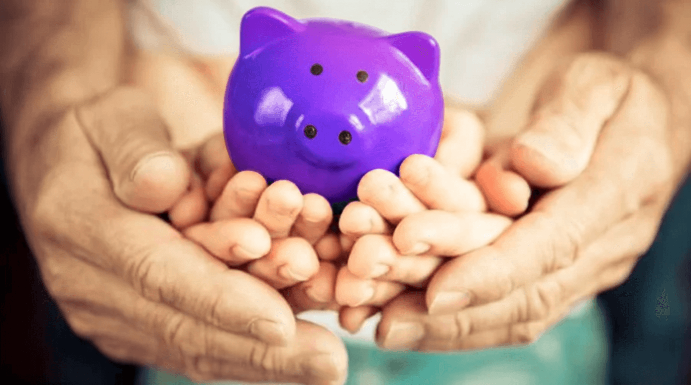 Manos de distintas generaciones sosteniendo juntas una alcancía, representando la protección del dinero de la familia