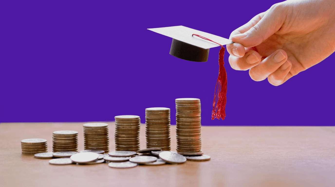 Birrete de graduación sobre pilas de monedas crecientes, representando una meta de ahorro educativo a largo plazo